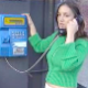 A woman uses a pay phone when all of a sudden, she gets the urge to shit. She proceeds to shit while talking on the pay phone without hesitation. Over 4 minutes.